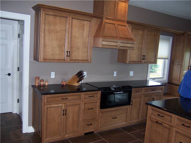 Maple cabinets stained with a glaze finish - Flat panel miter corner doors, drawer fronts, and side panels - Full overlay style - Quartz countertops
